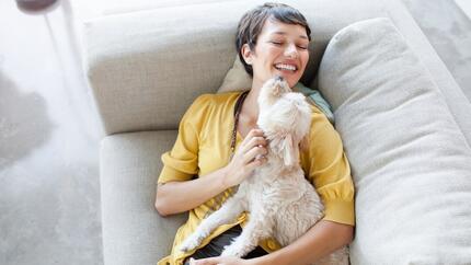 Donna che sorride e abbraccia un cane