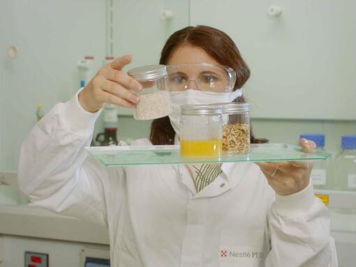 Donna scienziata che guarda gli ingredienti in un vaso